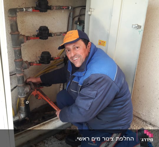 איש עם מפתח צינורות מתקן צנרת מים